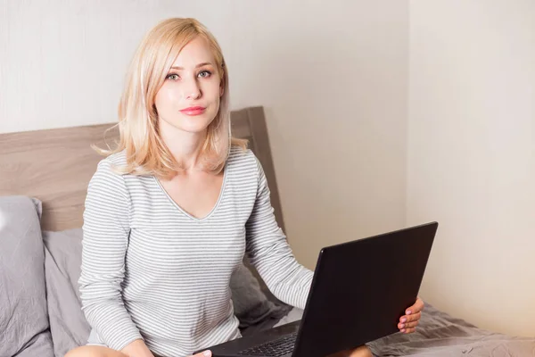 Mulher bonita usando laptop na cama — Fotografia de Stock