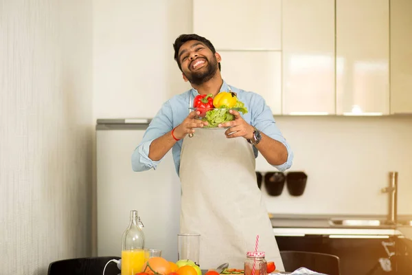 Handsome young man standing in the kitchen at home — Stock Photo, Image