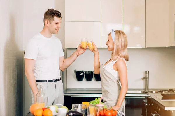 Couple making fresh organic juice in kitchen together — Stock Photo, Image