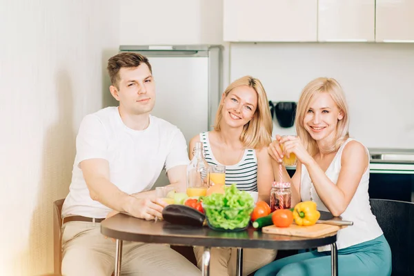 Amigos sentados à mesa na cozinha — Fotografia de Stock