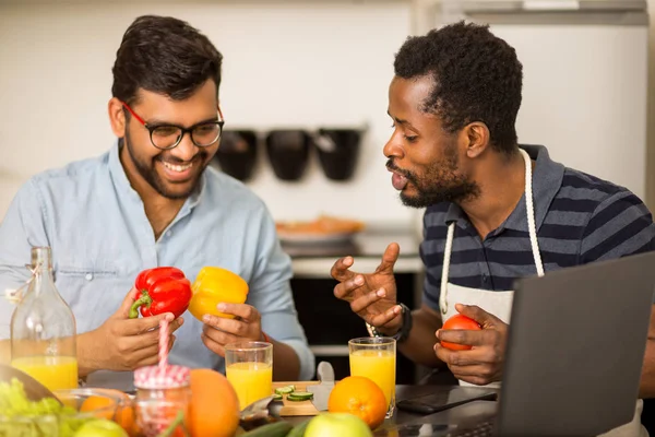 Dos hombres usando portátil en la cocina — Foto de Stock