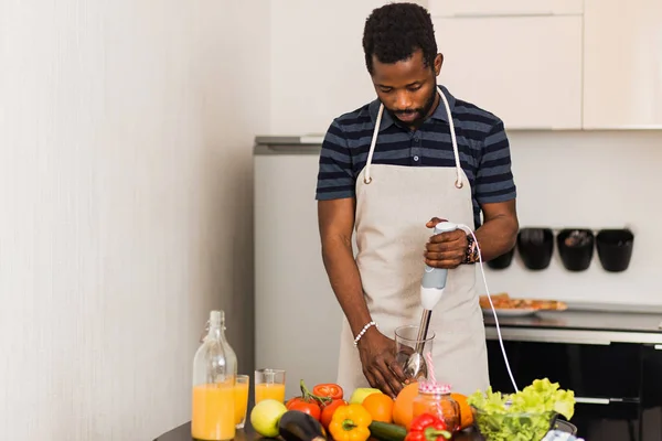 Hombre africano preparando comida saludable en casa en la cocina — Foto de Stock