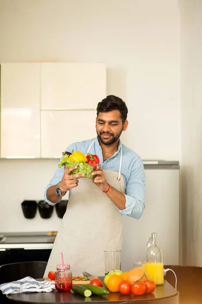 Bonito jovem de pé na cozinha em casa — Fotografia de Stock