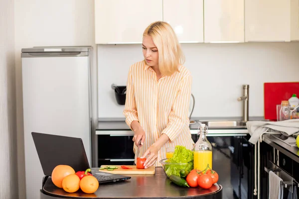 Mulher usando laptop na cozinha — Fotografia de Stock