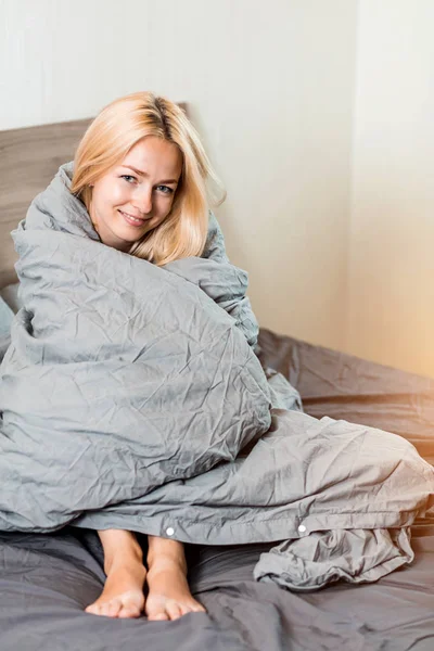 Positive Frau sitzt zu Hause im Bett — Stockfoto