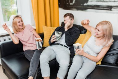 Evde patlamış mısır yiyen neşeli arkadaş grubu