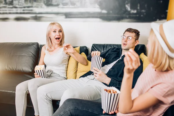 Alegre grupo de amigos comiendo palomitas en casa — Foto de Stock