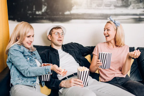 Alegre grupo de amigos comiendo palomitas en casa —  Fotos de Stock