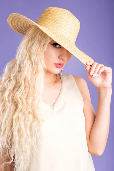 Красивая молодая женщина в шляпе на фиолетовом фоне — стоковое фото