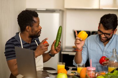 Mutfakta dizüstü bilgisayar kullanan iki adam
