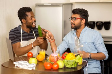 Mutfakta dizüstü bilgisayar kullanan iki adam