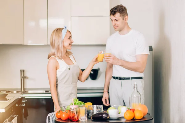 Couple making fresh organic juice in kitchen together — Stock Photo, Image
