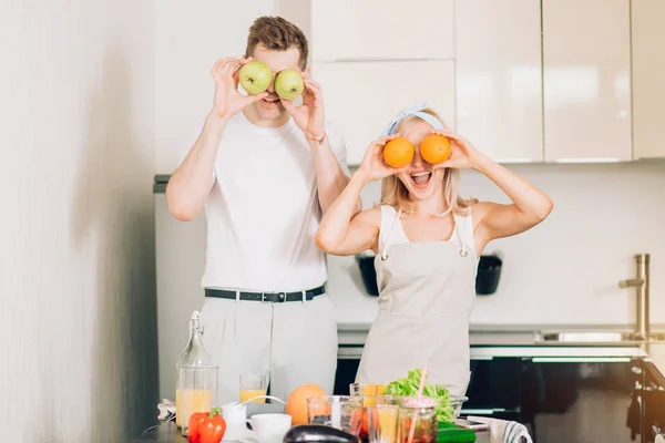 Casal fazendo suco orgânico fresco na cozinha juntos — Fotografia de Stock