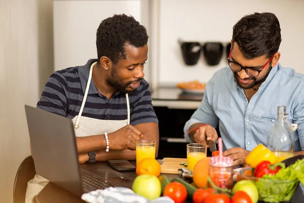 Dos hombres usando portátil en la cocina — Foto de Stock