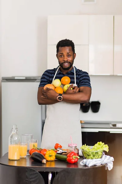 Afrykański mężczyzna przygotowuje zdrową żywność w domu w kuchni — Zdjęcie stockowe