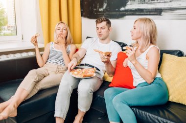 Arkadaşlar pizza yeme ve konuşan, evde birlikte vakit geçirmek