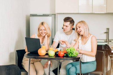 Mutfakta dizüstü bilgisayar kullanan arkadaşlar