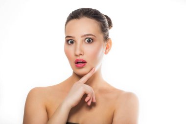 doğal makyaj ile genç güzel esmer kız, temiz cilt çıplak omuzlar çıplak omuzlar çene parmağı nda ağız açık el ile kameraya bakarak duygular jestler Spa vücut bakımı