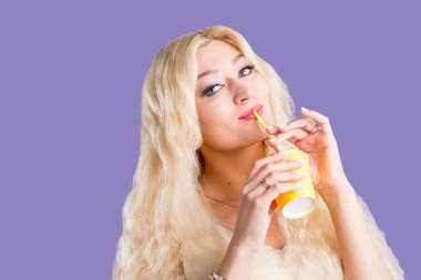 Mor stüdyo arka plan üzerinde kağıt fincan kahve içme güzel kadın