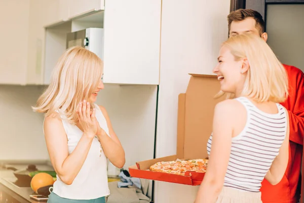 Dos jóvenes caucásicas recibiendo pizza del repartidor en casa — Foto de Stock