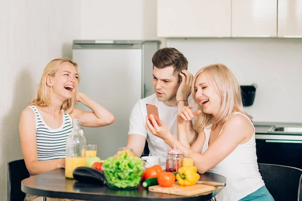 Amigos sentados à mesa na cozinha — Fotografia de Stock