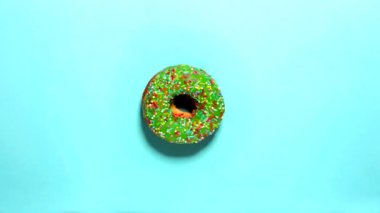 Mavi bir arka plan, üst görünümü üzerinde ortasında bir donut ile Interval video. renkler yeşil, pembe, yeşil, kahverengi ve sarı alternatif birbiri ardına