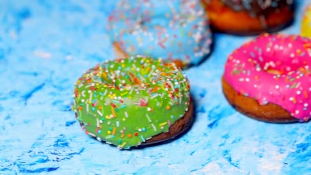 Красочные Вкусные Сладкие Пончики Вращаются Голубом Фоне Медленное Видео Крупным — стоковое видео
