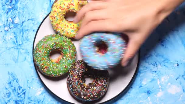 Mano Masculina Femenina Recoge Plato Blanco Las Rosquillas Verdes Rosadas — Vídeo de stock