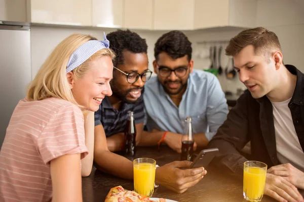 Jóvenes amigos usando el teléfono en la cocina —  Fotos de Stock