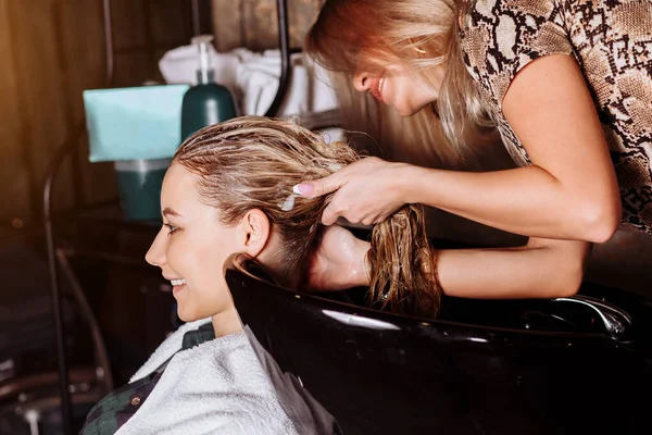 Mulher bonita lavando o cabelo em um salão de cabeleireiro — Fotografia de Stock