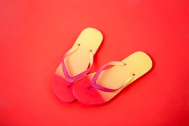 Kırmızı arka planda plaj parmak arası terlik