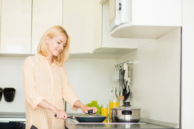 Sarışın kadın akşam yemeği hazırlanıyor