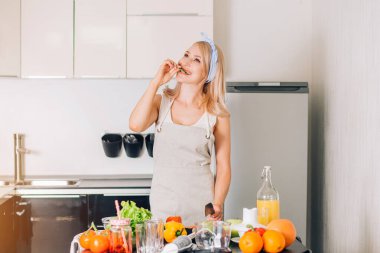 Genç bir kadın mutfakta yemek pişiriyor.