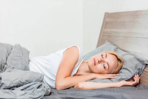 Genç kadın yatakta uyuyor.