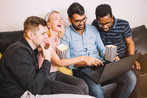 A group of friends using laptop and laughing