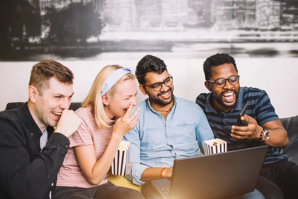 Un grupo de amigos usando el portátil y riendo — Foto de Stock