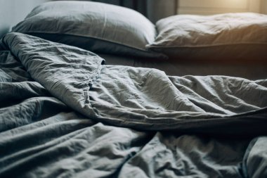 Mavi yatak çarşafları ve yastıklar gece uykusundan sonra.