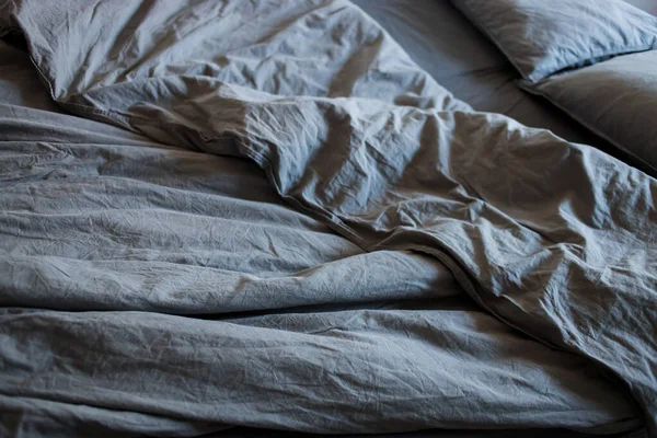 Mavi yatak çarşafları ve yastıklar gece uykusundan sonra.