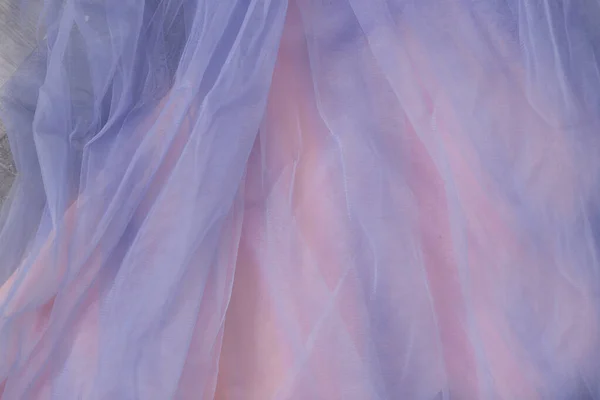 Nahaufnahme aus dünnem blauen Tüll auf rosa Hintergrund — Stockfoto