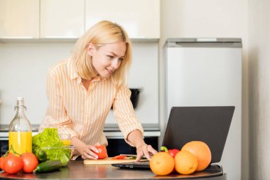 Mutfakta dizüstü kullanan kadın