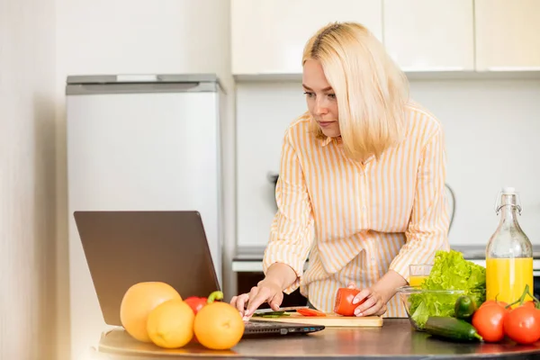 Mulher usando laptop na cozinha — Fotografia de Stock