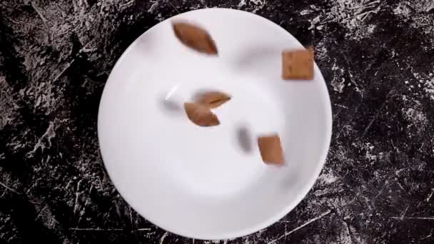 Шоколадні подушечки кукурудзяні пластівці в білій мисці ізольовані на білому тлі. Зернові . — стокове відео