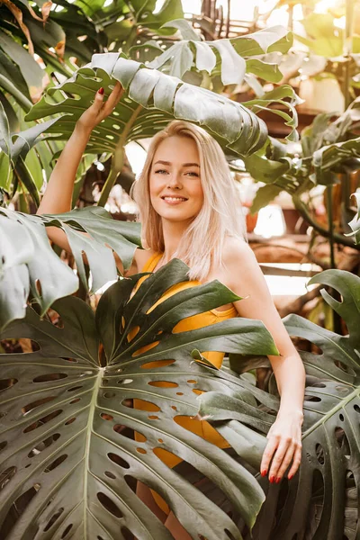 Güzel mayo giymiş, yağmur ormanlarında poz veren, yazın tadını çıkaran, doğada vakit geçiren muhteşem bir kadın portresi. Doğal güzellik konsepti. Sarışın kız kameraya gülümsüyor..