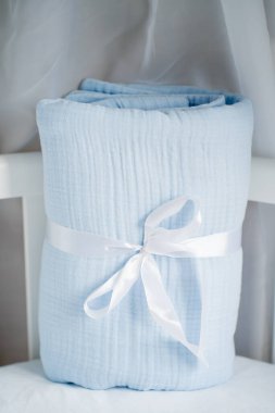Güzel mavi paketli bebek muslin battaniyesi karyolada fiyonklu. Yeni doğmuş bir bebek için hediye
