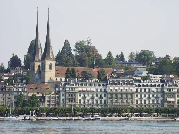 Perwakilan bangunan hotel dan gereja St. Leodegar di kota european di danau Swiss — Stok Foto