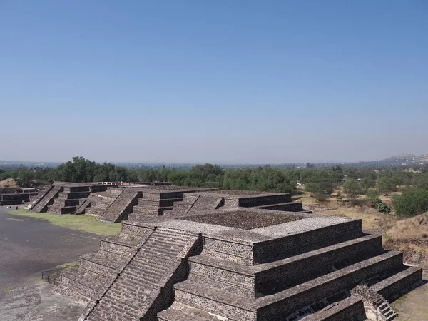Quatro pirâmides pedregosas em ruínas de Teotihuacan vistas da avenida dos mortos perto da paisagem da cidade de México — Fotografia de Stock