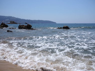 Meksika 'da ACAPULCO şehrindeki kayaların tropikal manzarası Pasifik Okyanusu dalgaları kumlu sahil manzaraları ve 2018' de açık mavi gökyüzü sıcak kış günü, Kuzey Amerika 'da Mart ayında.