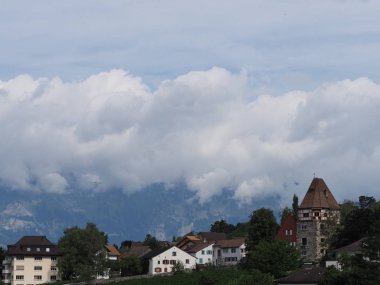 Avrupa 'nın başkenti Vaduz, Lihtenştayn' ın üzerindeki şehir manzarasında, 2018 'in ılık yaz gününde bulutlu gökyüzü ile taşlı kule ve güzel konut arazisi..