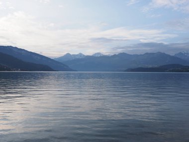 Thun Gölü ve Alpler Dağları manzaraları Ağustos 2018 soğuk güneşli sabah günü bulutlu mavi gökyüzü ile İsviçre'nin Thun Avrupa kentinden görülen.