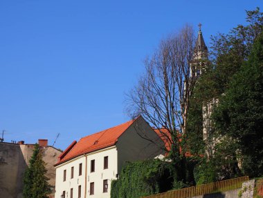 Kırmızı çatılı ve Polonya 'nın Bielsko-Biala kentindeki St. Nicholas Katedrali' nin kulesi olan beyaz ev.